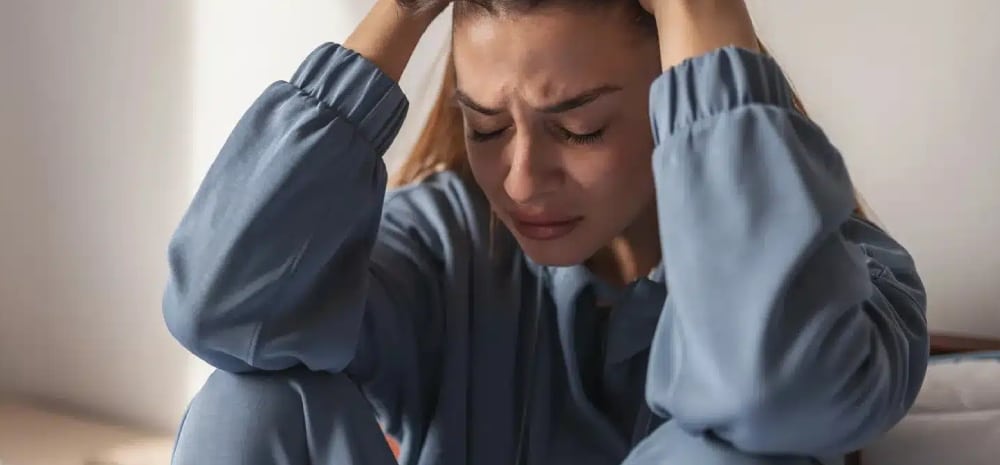 mujer con las manos en la cabeza deprimida