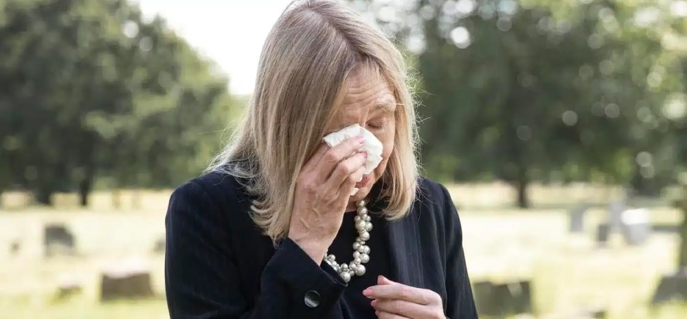 mujer llorando en un cementerio