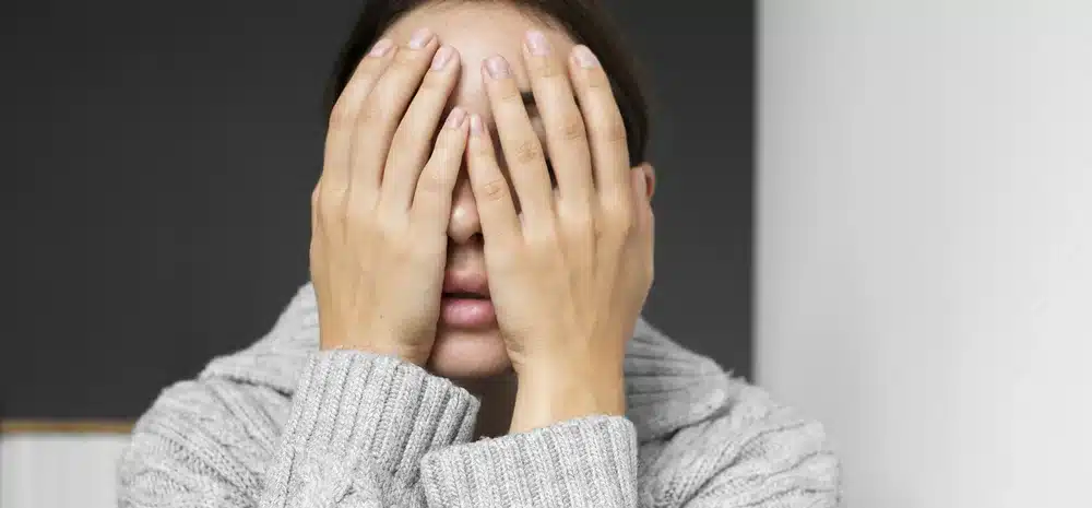 retrato mujer joven con baja autoestima sentada escaleras casa min